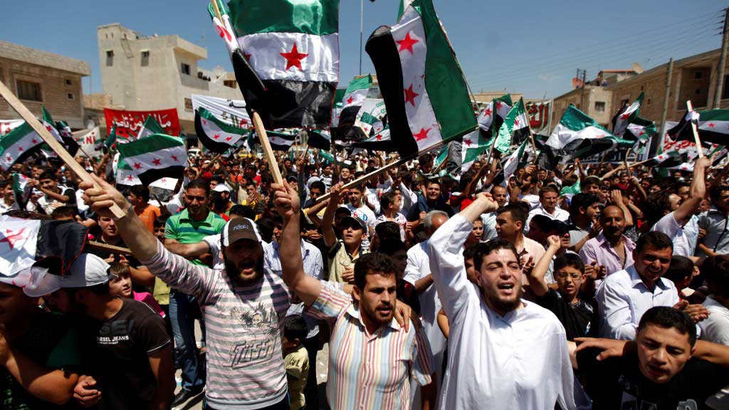 Syrer während einer Anti-Assad-Demo nach dem Freitagsgebet in der Rebellenhochburg Idlib; Foto: AP