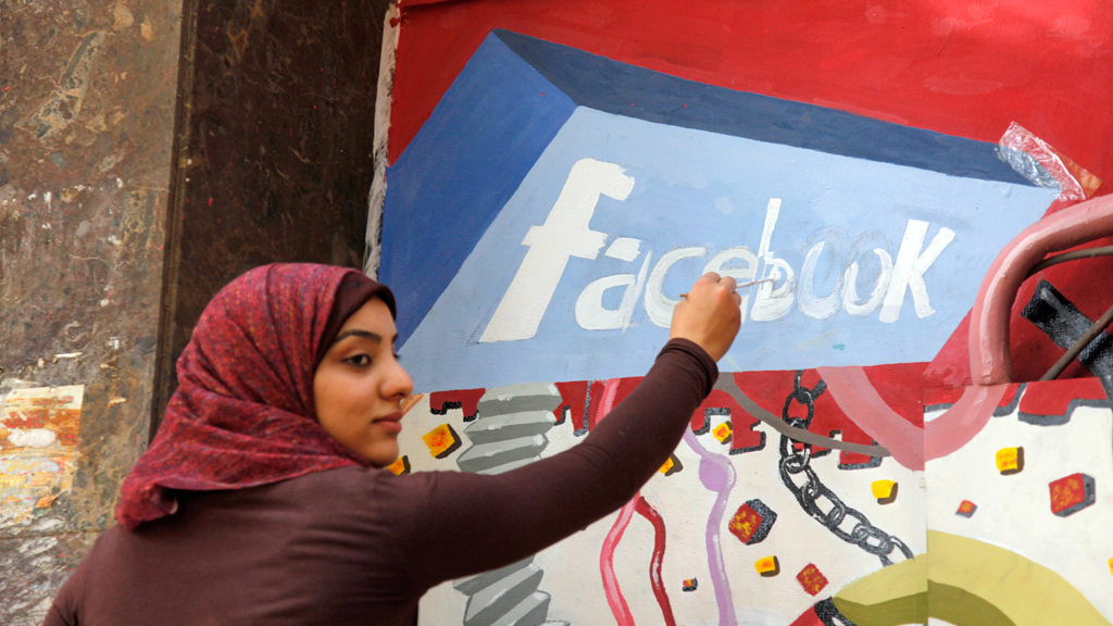 Kunststudentin der Universität Helwan zeichnet ein Facebook-Logo an einer Gedanktafel anlässlich des Sturzes von Hosni Mubarak in Ägypten; Foto: picture alliance/AP/M. Deghati