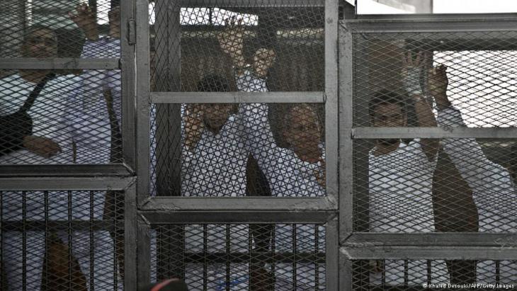 Arrested Al-Jazeera journalists held in a cage during their trial in Cairo in March 2014 (photo: AFP/Getty Images)