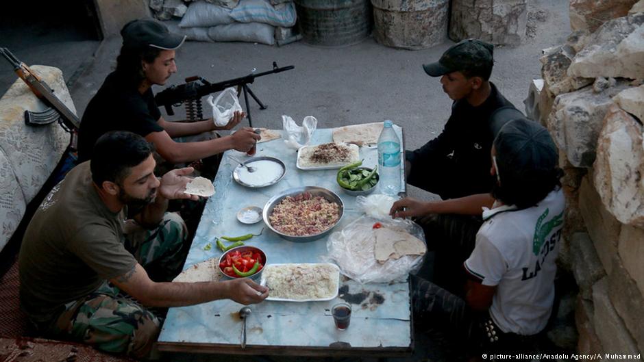 Syrische Rebellen während des Fastenbrechens in Sheikh Said, Aleppo, 6.05.2016; Foto: picture-alliance/Anadolu Agency/A. Muhammed