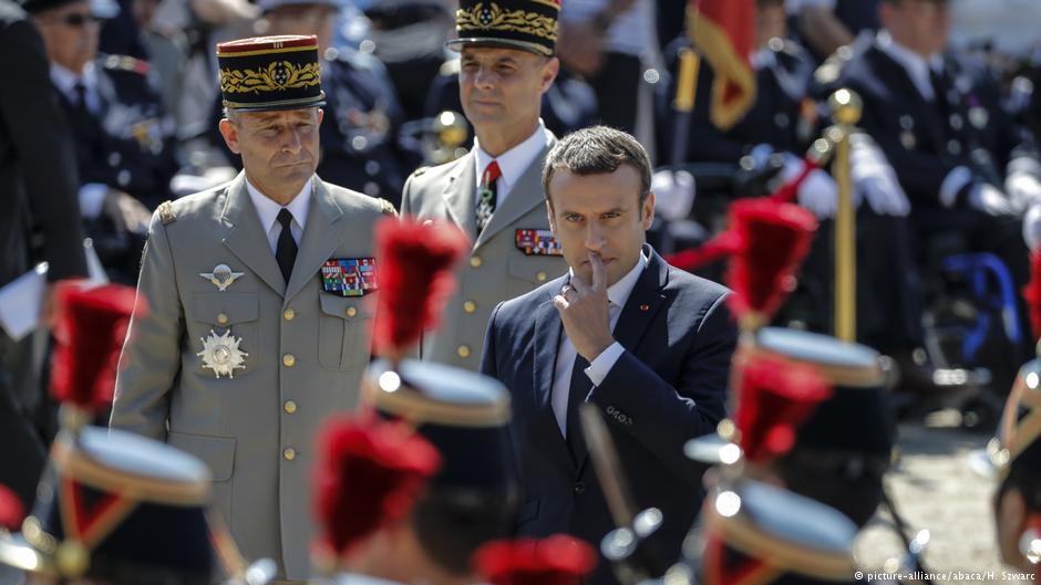 الرئيس الفرنسي إيمانويل ماكرون عند قصر الإيليزيه في باريس وإلى جانبه جنرالان فرنسيان.