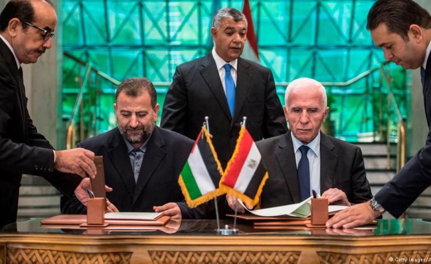 Hamas representative Saleh al-Arouri and Fatah's negotiator Azzam al-Ahmed sign the reconciliation agreement in Cairo under the watchful eye of Khaled Fawzy, the head of Egypt′s General Intelligence Directorate (photo: Getty Images/AFP/K. Desouki)