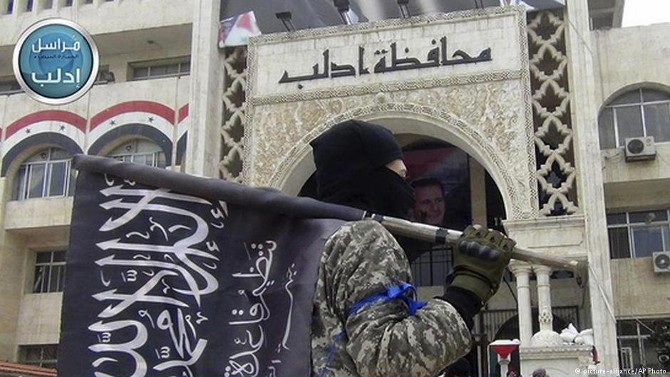 Kämpfer der Al-Nusra-Front vor dem zentralen Verwaltungsgebäude der Provinz Idlib; Foto: AP/picture-alliance