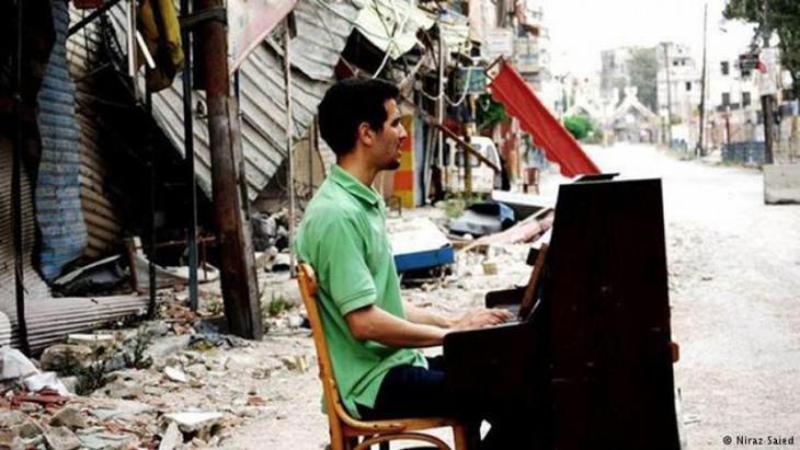 Aeham Ahmad playing his piano among the rubble, Syria (photo: Niraz Saied)