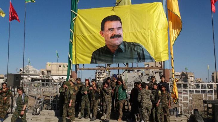 Einheiten der "Syrian Democratic Forces" vor einem Poster Öcalans nach der Einnahme Rakkas am 19. Oktober 2017; Foto: AFP/Getty Images