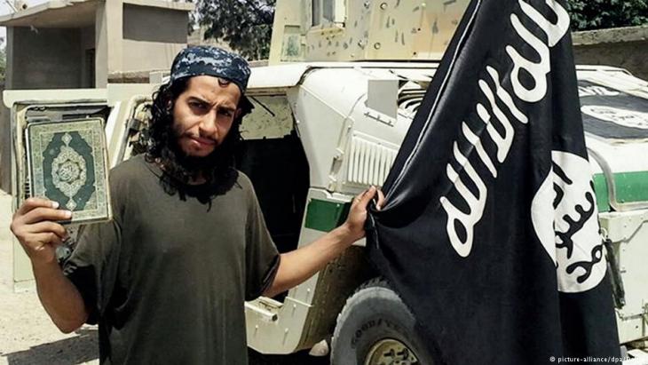 IS terrorist Abdelhamid Abaaoud with the IS flag and Koran (photo: picture-alliance/dpa)