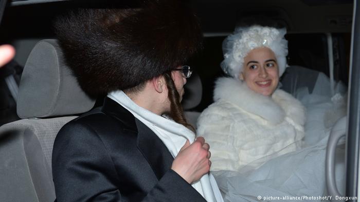 Hasidic man with fur hat and woman wearing a curly white wig in a car (photo: picture-alliance/Photoshot/Y. Dongxun)