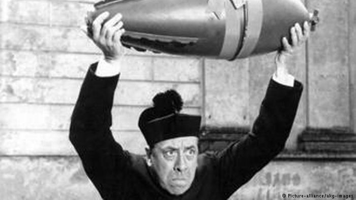 Film still: Don Camillo holds a bomb high over his head (photo: picture-alliance/akg-images)