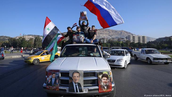 Assad supporters wave Syrian, Russian and Iranian flags in Damascus (photo: picture-alliance/AP)