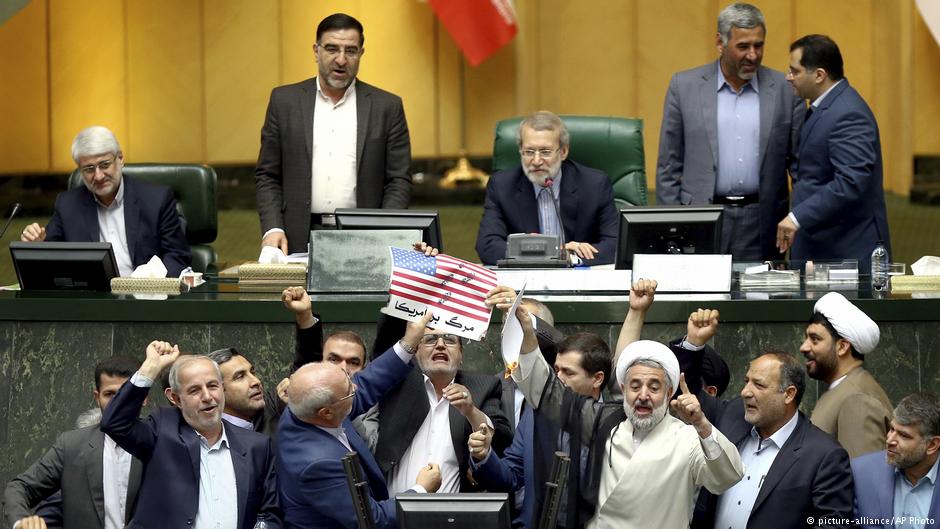 Iranian lawmakers burn pieces of papers representing the U.S. flag and the nuclear deal as they chant slogans against the U.S. at the parliament in Tehran on 9 May 2018 (AP Photo)
