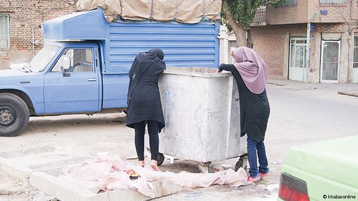 فتاتان تبحثان عما يمكن أحذه من برميل القمامة في طهران - إيران.