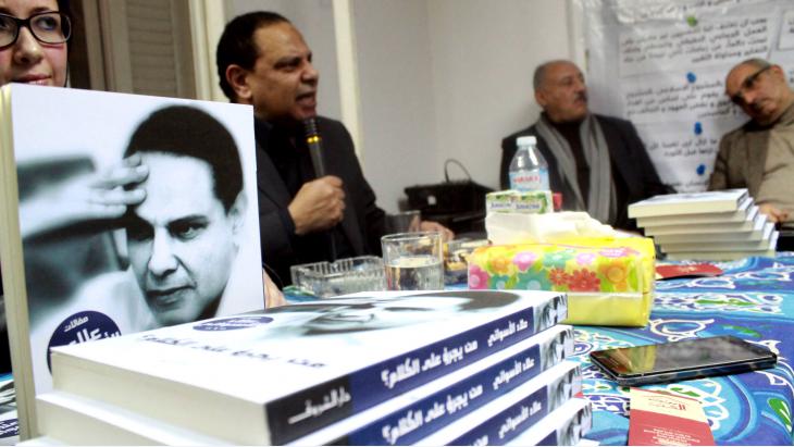 Al Aswany at a discussion of his latest novel "The Republic As If" (pictured in the foreground) in Cairo (photo: Dar al-Adab publishing house)