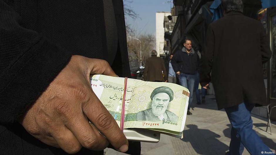 عملة ورقية إيرانية عليها صورة الخميني في يد أحد الأشخاص في الشارع – إيران.