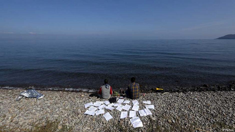 Two Syrian refugee students dry their documents on a beach on the Greek island of Lesbos, 19 October 2015 (photo: Reuters/Yannis Behrakis)