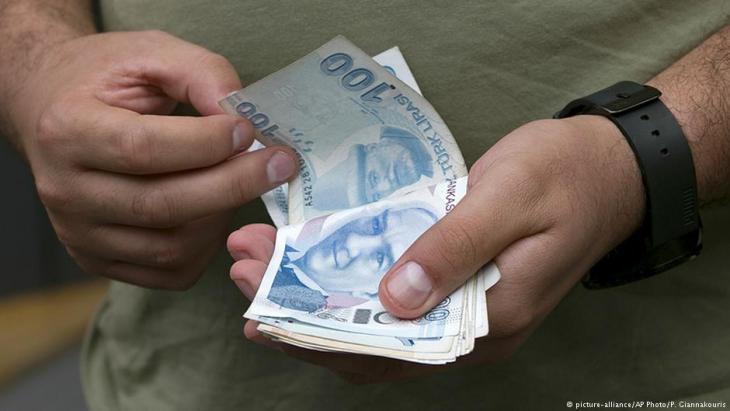 Man counting Turkish banknotes at a bureau de change in Istanbul (photo: picture-alliance/AP)