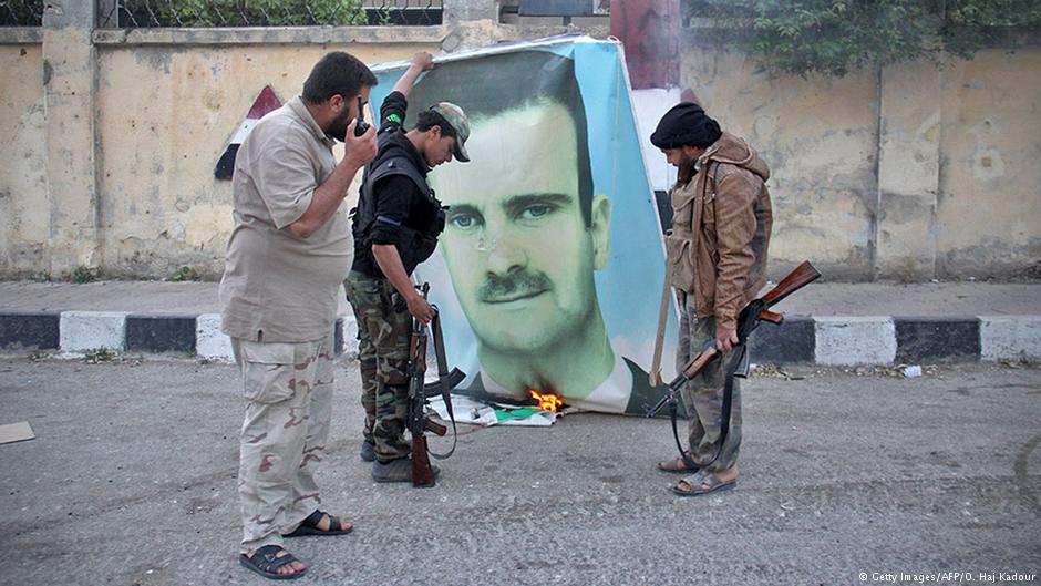 مقاتلون معارضون يحرقون صورة الأسد - سوريا.