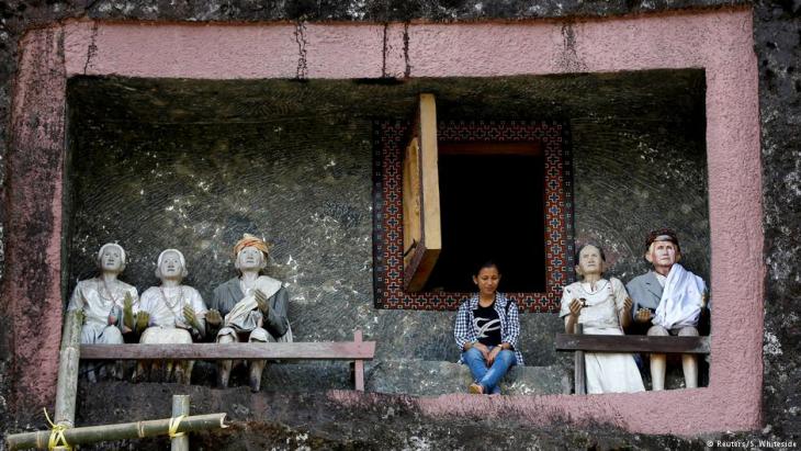 The twenty-one year-old mining engineer in front of the tomb of his deceased great-grandmother in Toraja (photo: Darren Whiteside/Reuters)