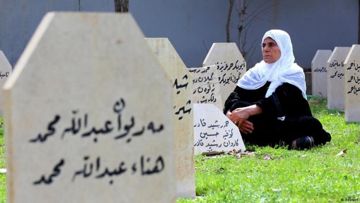 A woman sits among the graves of victims of the Halabja chemical attack (photo: Reuters)