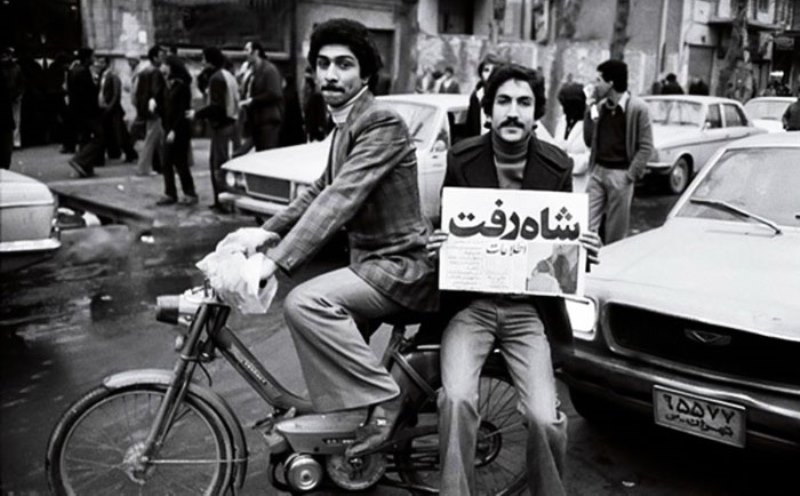 In Teheran hält ein Fahrradfahrer nach dem Sturz des Schahs einen Zeitungsartikel mit der Überschrift "Der Schah ist fort"; Quelle: Iran Journal