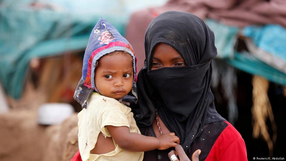 A girl carries a child near a hut in an improvised camp for internally displaced people near Abs of the northwestern province of Hajja, Yemen, 18 February 2019 (Reuters/K. Abdullah)