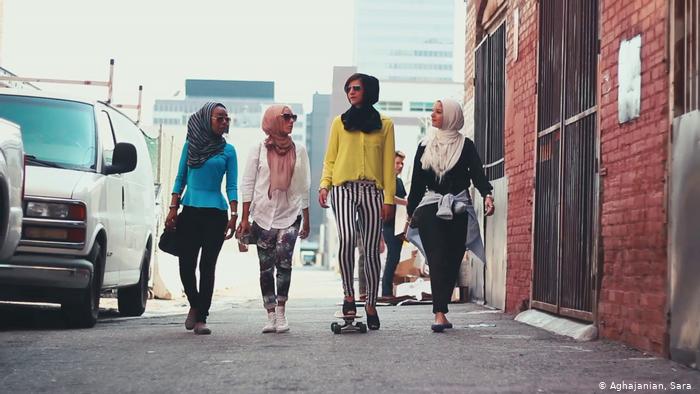 Four young women with headscarves walk along a street (photo: Sara Aghajanian)