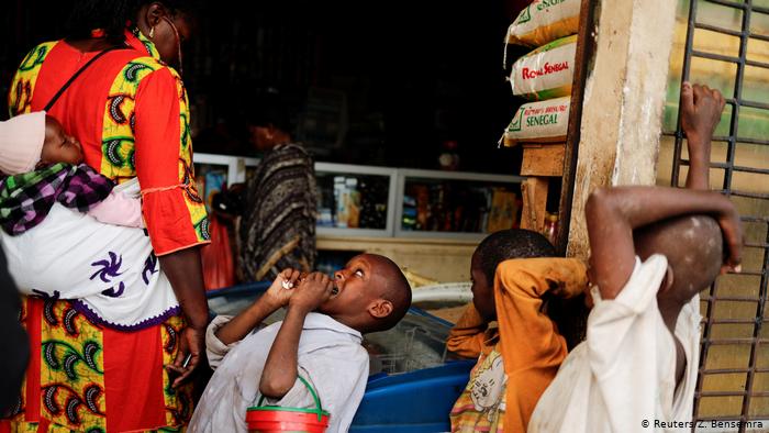 Amadou, 7, looks at a woman as he begs at the entrance to a shop(photo: Zohra Bensemra)