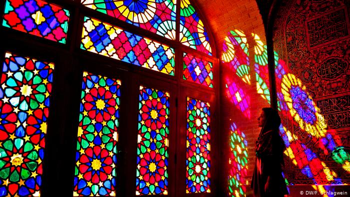 A tourist stands in the coloured lights from the stained glass windows in the Mosque of Nasir-ol-Molk (photo: DW/F. Schlagwein)