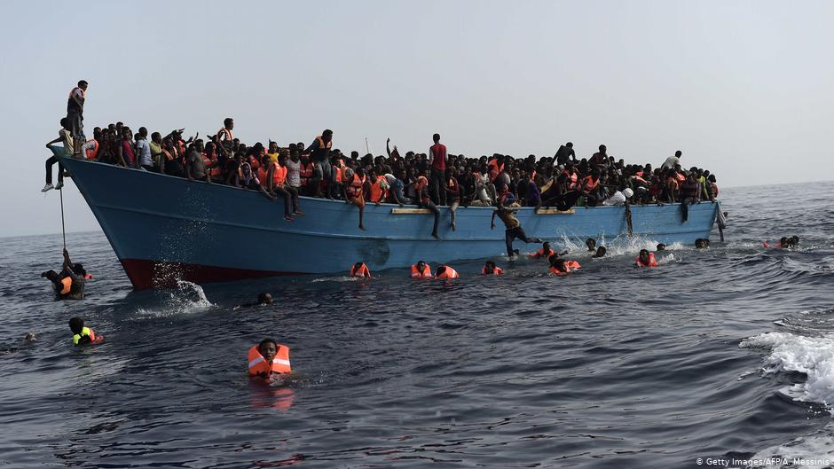 لاجئون يقفزون من قارب في البحر.