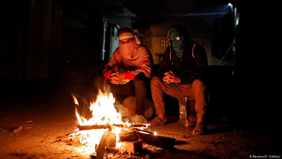Kashmiri men on night-time guard duty warm themselves at a barricade (photo: Reuters/D. Siddiqui)