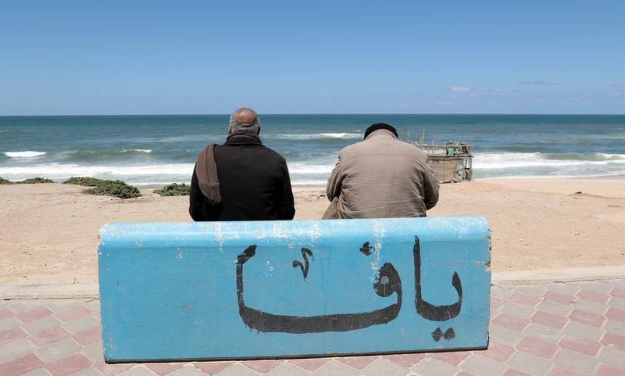Palästinensische Fischer am Strand von Gaza vor einem Stein mit der Aufschrift Jaffa; Foto: Reuters