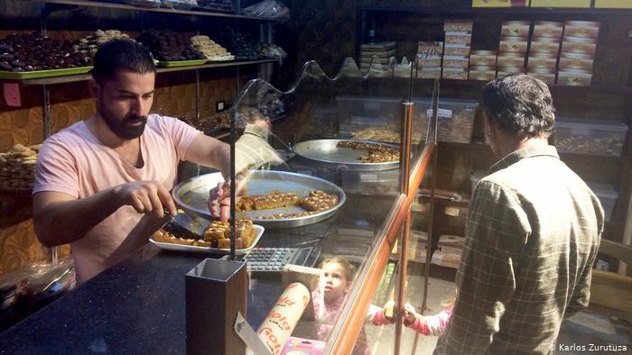 A customer buys baklava at a bakery in Derik
