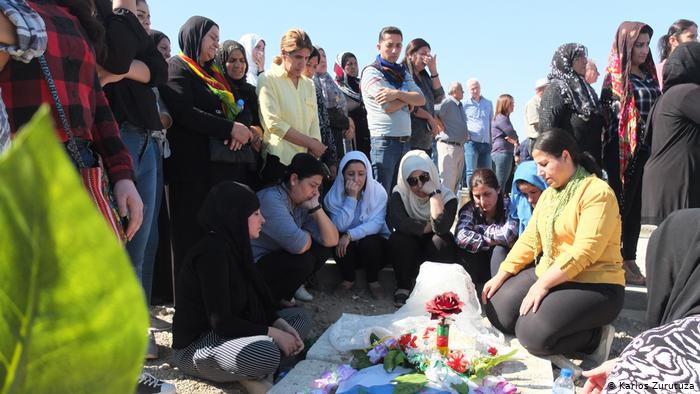A family at the grave of a Kurdish fighter