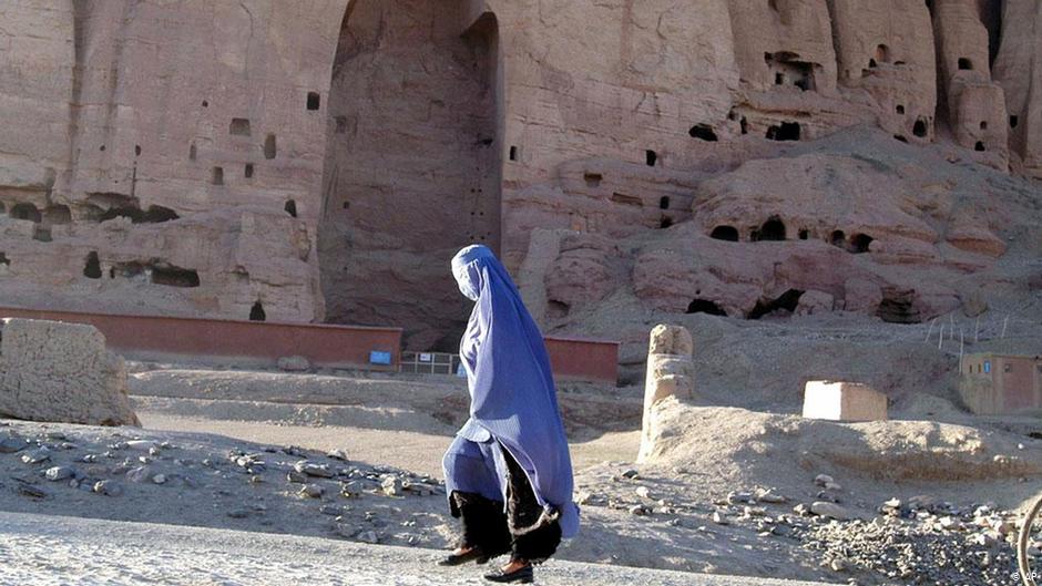 A woman walks past an enormous Buddha niche carved into the rock face in Bamiyan province, Afghanistan, 2007. The ancient Buddha statues were destroyed by the Taliban in March 2000, despite a national and international outcry to halt the destruction (photo: AP Photo/Amir Shah)