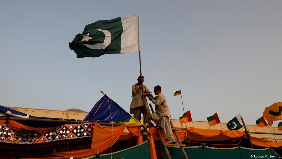 Men install Pakistan's national flag on a stall ahead of the Hazara Culture Day celebration at the Qayum Papa Stadium in Mariabad, Quetta (photo: Reuters/A. Soomro)