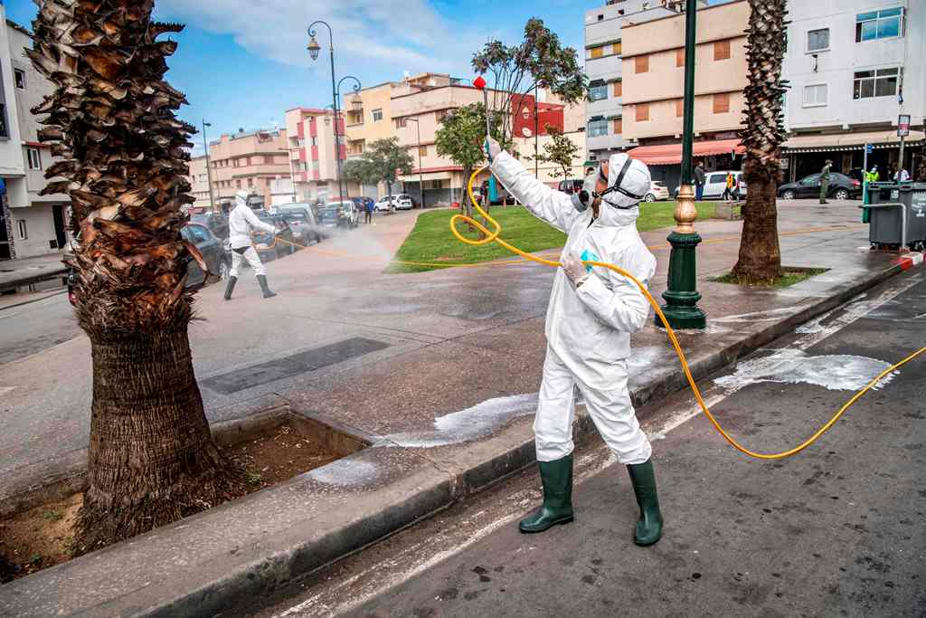 عامل في وزارة الصحة المغربية يعقم أشجارا في العاصمة المغربية الرباط، في 22 مارس 2020