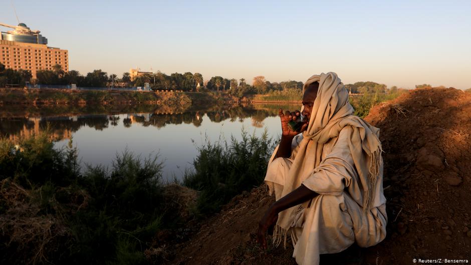 Mohamed Ahmed al Ameen, 55, a brick maker, drinks a cup of tea as he sits on the edge of the Blue Nile near an open-air factory on Tuti Island, Khartoum, Sudan, 14 February 2020 (photo: REUTERS/Zohra Bensemra)