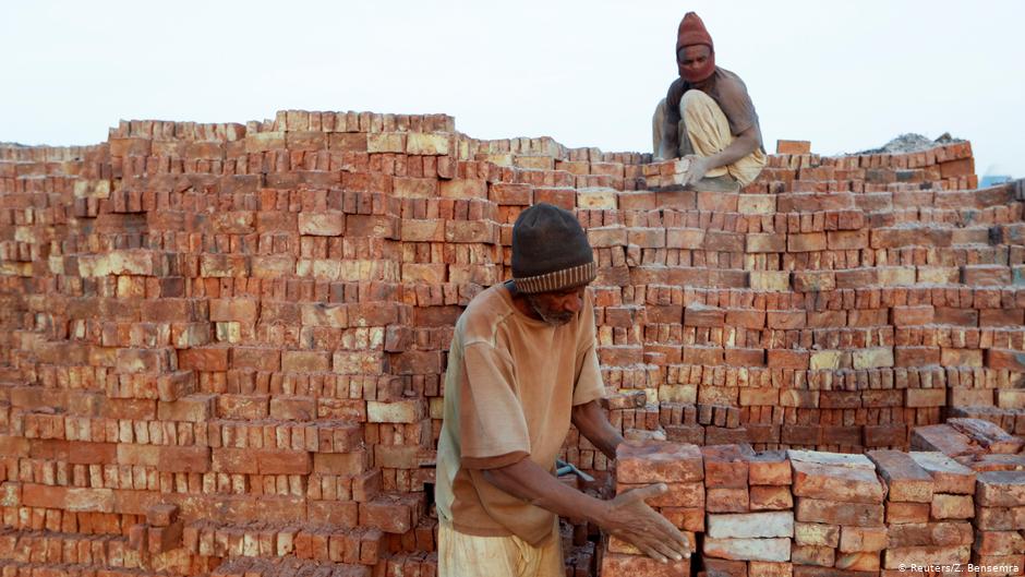 Mustapha, 60, a brick maker, piles up bricks after removing them from a kiln at an open-air factory on Tuti Island, Khartoum, Sudan, 20 February 2020 (photo: REUTERS/Zohra Bensemra) 