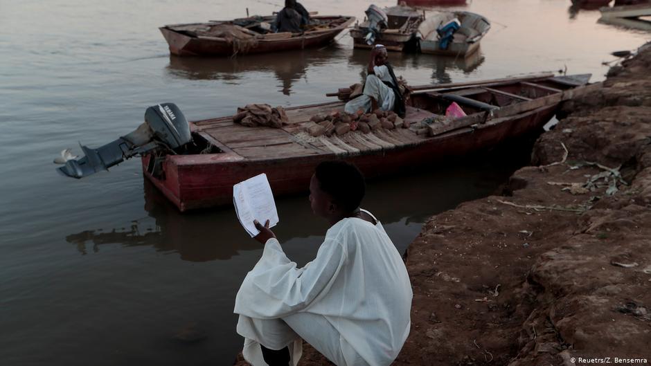 A high school student reads his lesson notes as he sits by a bank on the Nile river in Alqamayir, Omdurman, Sudan, 15 February 2020 (photo: REUTERS/Zohra Bensemra)