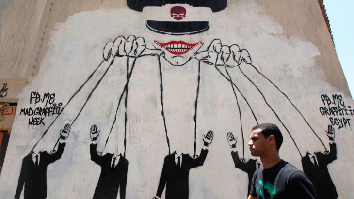 رسم جداري قرب ميدان التحرير في القاهرة في مصر يُظهِر أن الجيش يتحكم بخيوط كل شيء في البلاد.  (photo: Reuters)