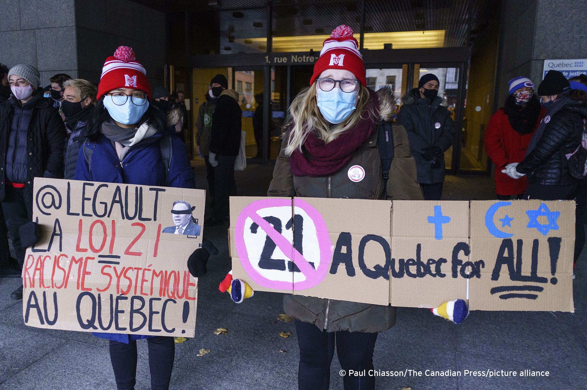 Demonstrators stand outside the courthouse on the first day of the constitutional challenge to Bill 21, which bans public workers in positions of "authority" from wearing religious symbols, before the Quebec Superior Court in Montreal on 2 November 2020 (photo: THE CANADIAN PRESS/Paul Chiasson)