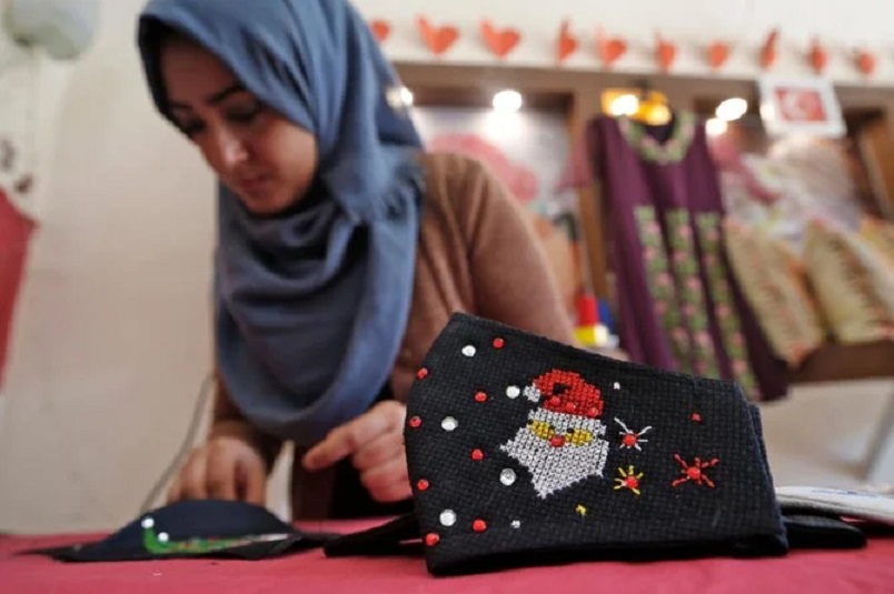A Palestinian woman works on Christmas-themed masks in Gaza City on 9 December 2020.
