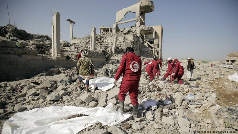 Aid workers recover dead bodies from the rubble of a prison in Yemen after an air strike by the Saudi military coalition (photo: Hani Al-Ansi/dpa/picture-alliance)