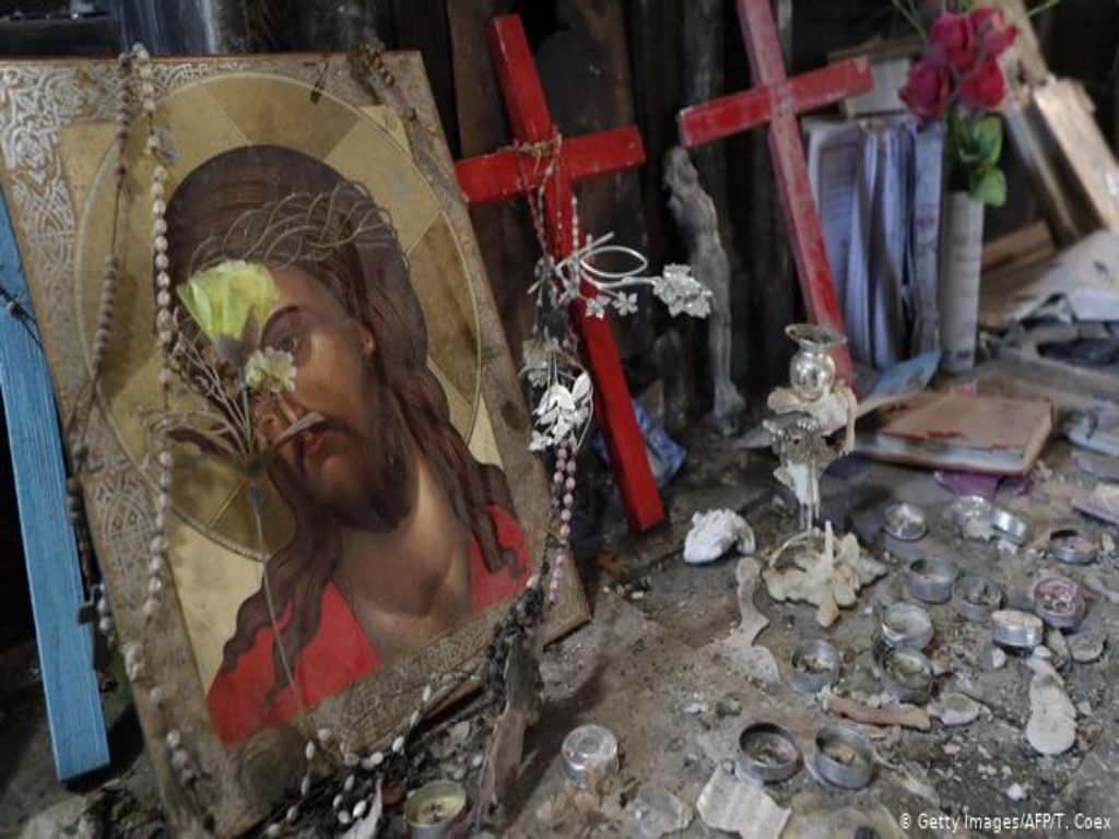 Zerstörte Gegenstände in einem Kirchenraum: Ein Jesusbild udn kerzeln liegen auf dem Boden; Foto: Getty Images/AFP/T. Coex