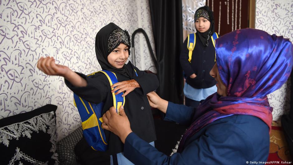 Afghan sisters getting ready to leave for school in Kabul (photo: Getty Images/AFP/W. Kohsar)