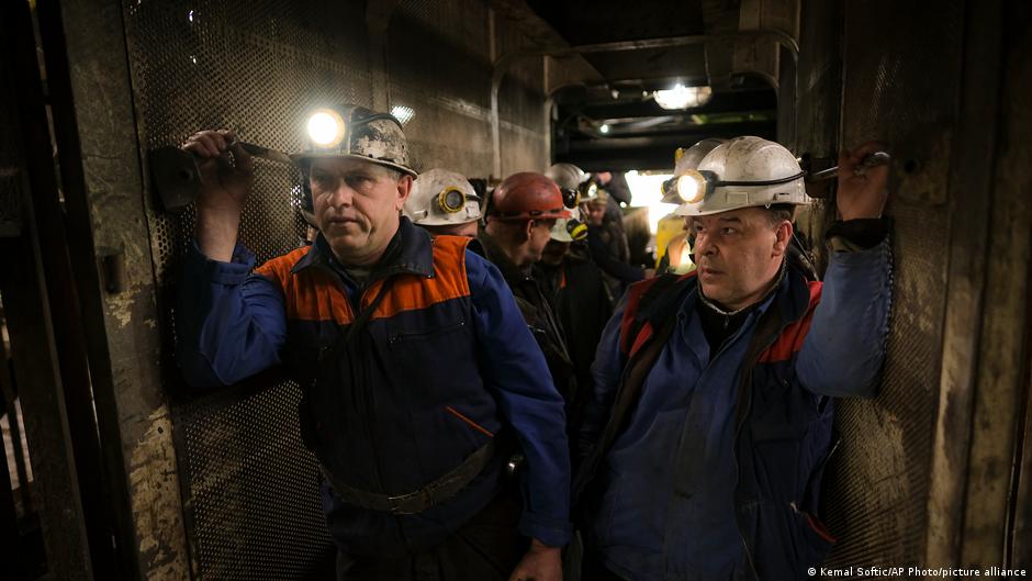 Bosnian coal miners hold bags of food as they stand in an elevator taking them underground at a mine in Zenica, Bosnia, 29 April 2021 (photo: AP Photo/Kemal Softic)
