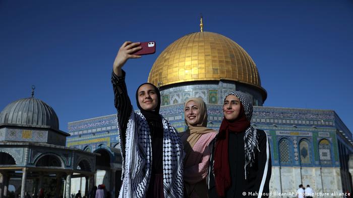 Women pose for a selfie in front of the Dome of the Rock