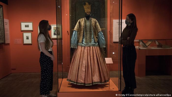  Museum staff members looks at a woman's jacket, blouse and skirt from 1840-50, on show ahead of the Epic Iran exhibition