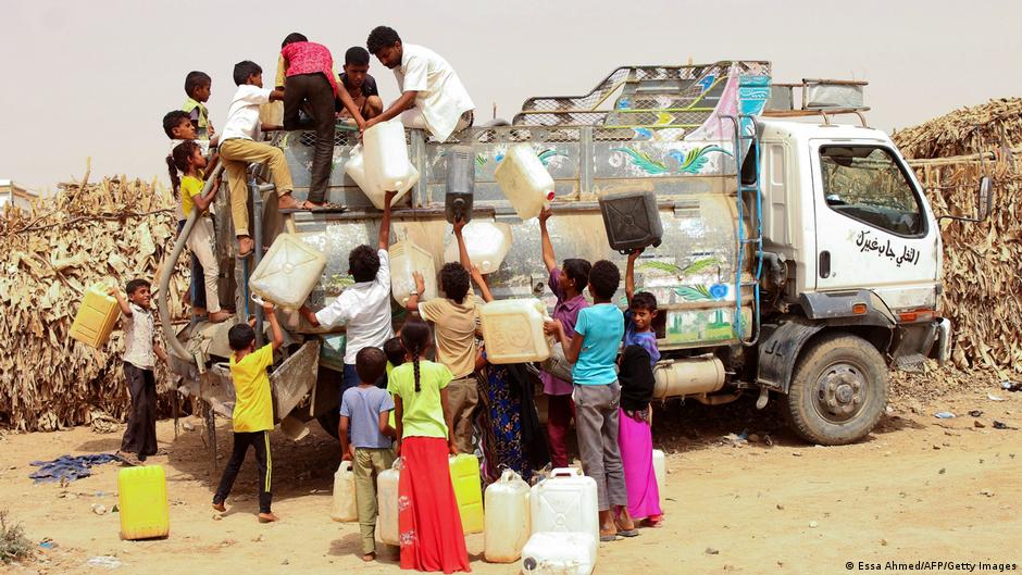 أطفال في اليمن يجلبون الماء من شاحنة حاملة للمياه.
