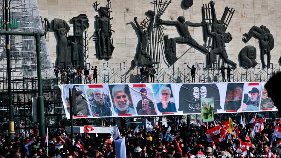 Supporters of the Popular Mobilization Forces hold a posters of Abu Mahdi al-Muhandis, deputy commander of the Popular Mobilization Forces, front, and General Qassem Soleimani, head of Iran's Quds force during a protest, in Tahrir Square, Iraq, 3 January 2021 (photo: Khalid Mohammed/picture-alliance)