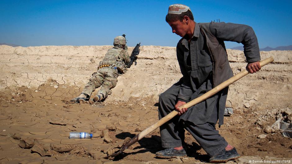 An Afghan boy works at a construction site as a U.S. Army soldier of 3/1 AD Task Force Bulldog takes position during a joint patrol with Afghan National Army (ANA) in a village in Kherwar district in Logar province, eastern Afghanistan, 23 May 2012 (photo: REUTERS/Danish Siddiqui)